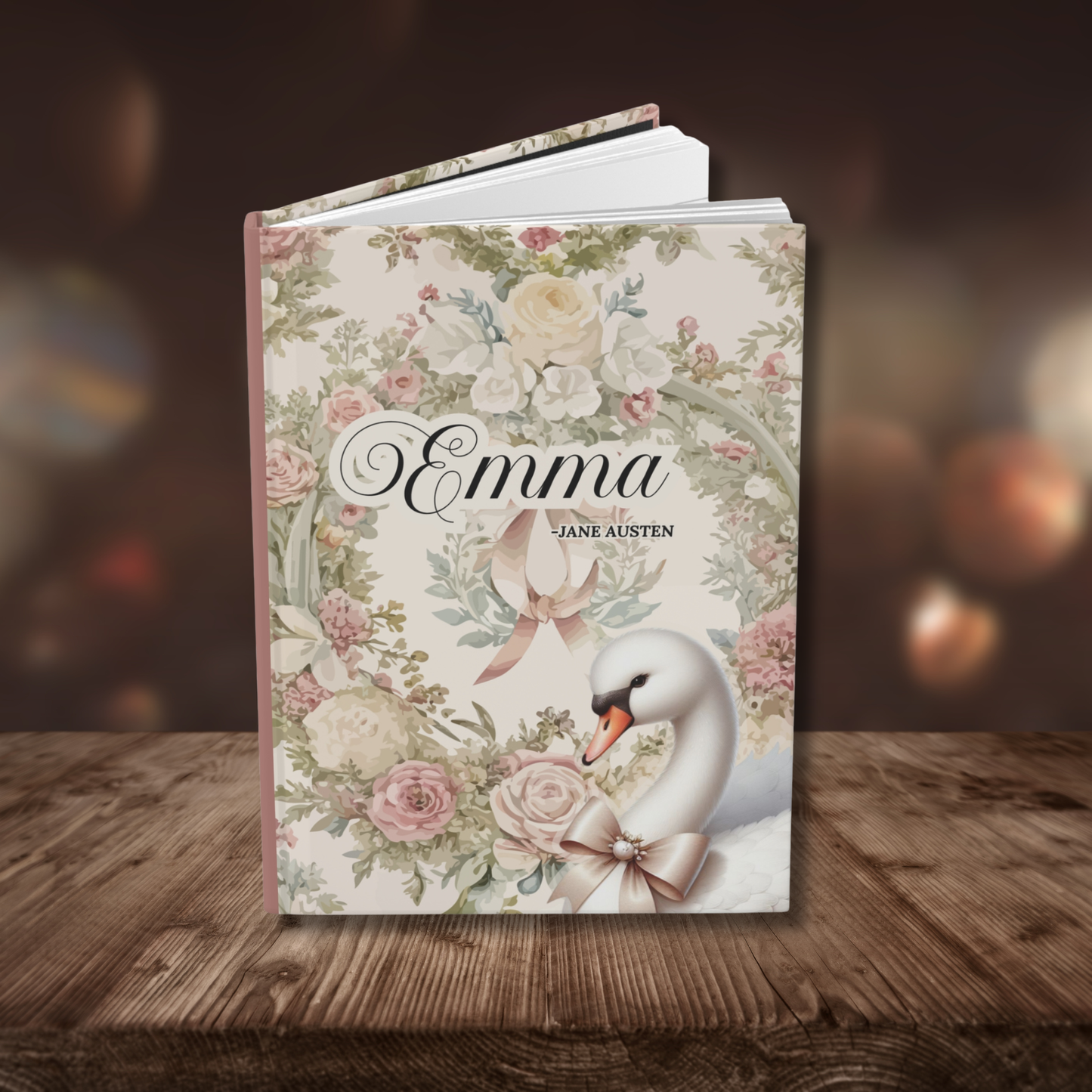 Journal titled 'Emma' by Jane Austen with floral toile design and swan illustration on a wooden surface.