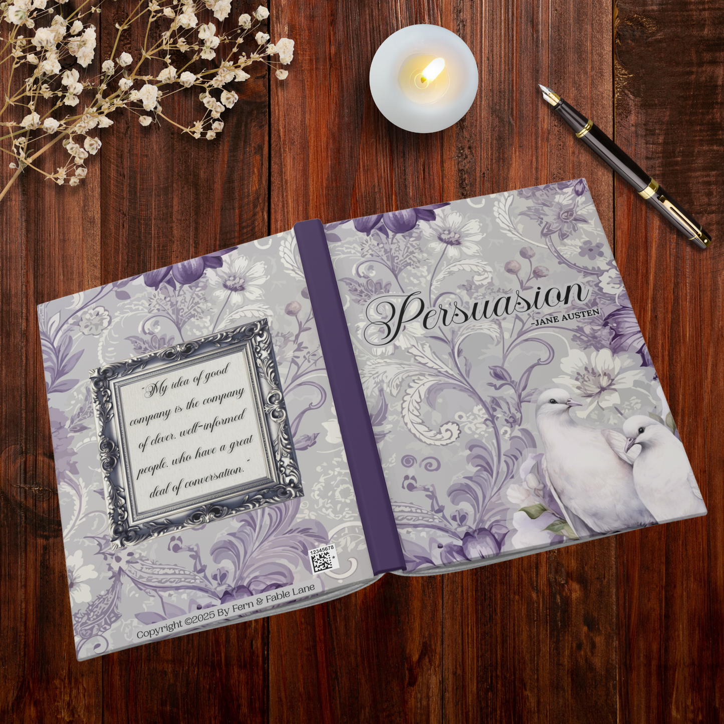 Notebook open and laying face down to show both front and back covers. Front cover has the title 'Persuasion' by Jane Austen. Two white doves are in the lower left corner, with decorative cover. Back cover has the image of a silver frame with the quote, “My idea of good company is the company of clever, well-informed people, who have a great deal of conversation.” The notebook is laying on a wooden surface.
