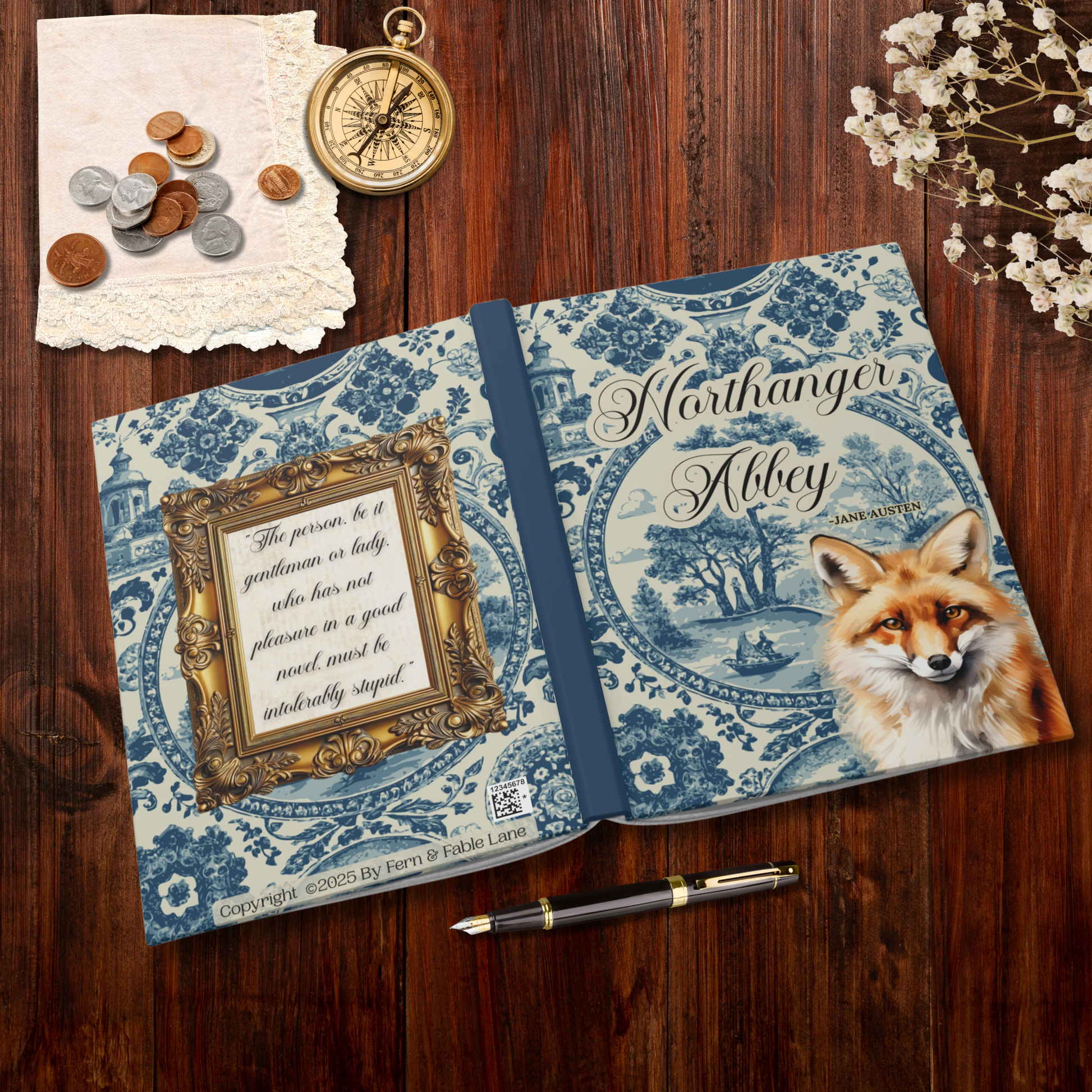 Decorative notebook with fox illustration on a wooden surface with coins and a compass.