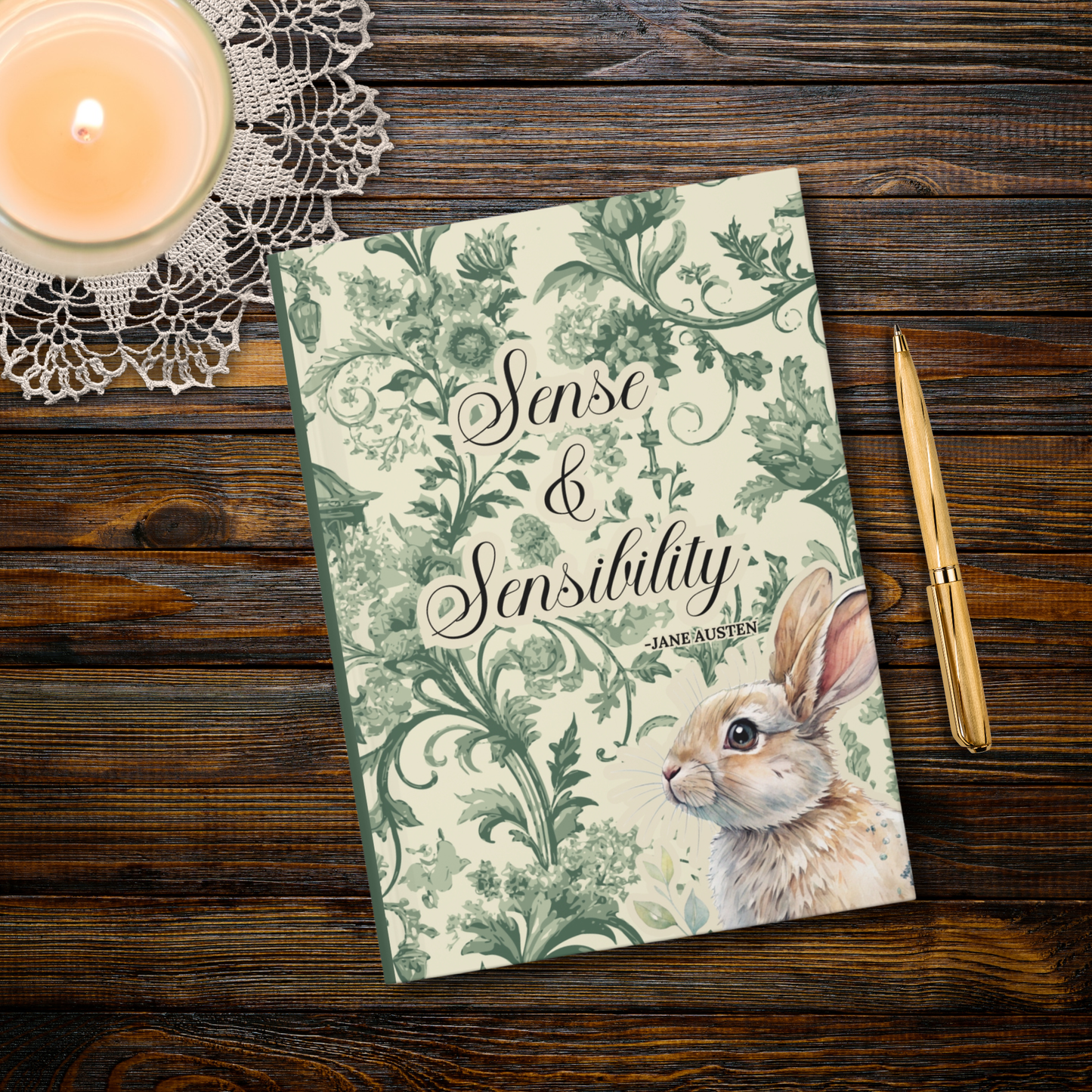 Journal titled 'Sense & Sensibility' by Jane Austen with a rabbit illustration on a wooden surface with a candle and pen.