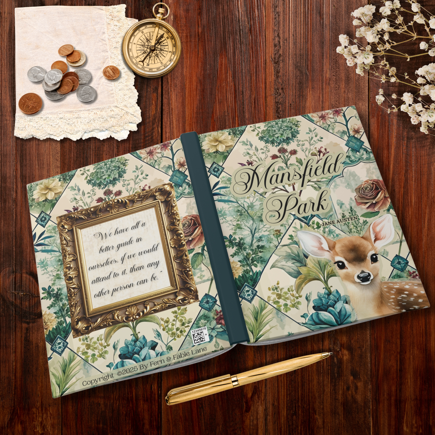 Notebook with floral design and deer illustration on a wooden surface with coins and a compass.