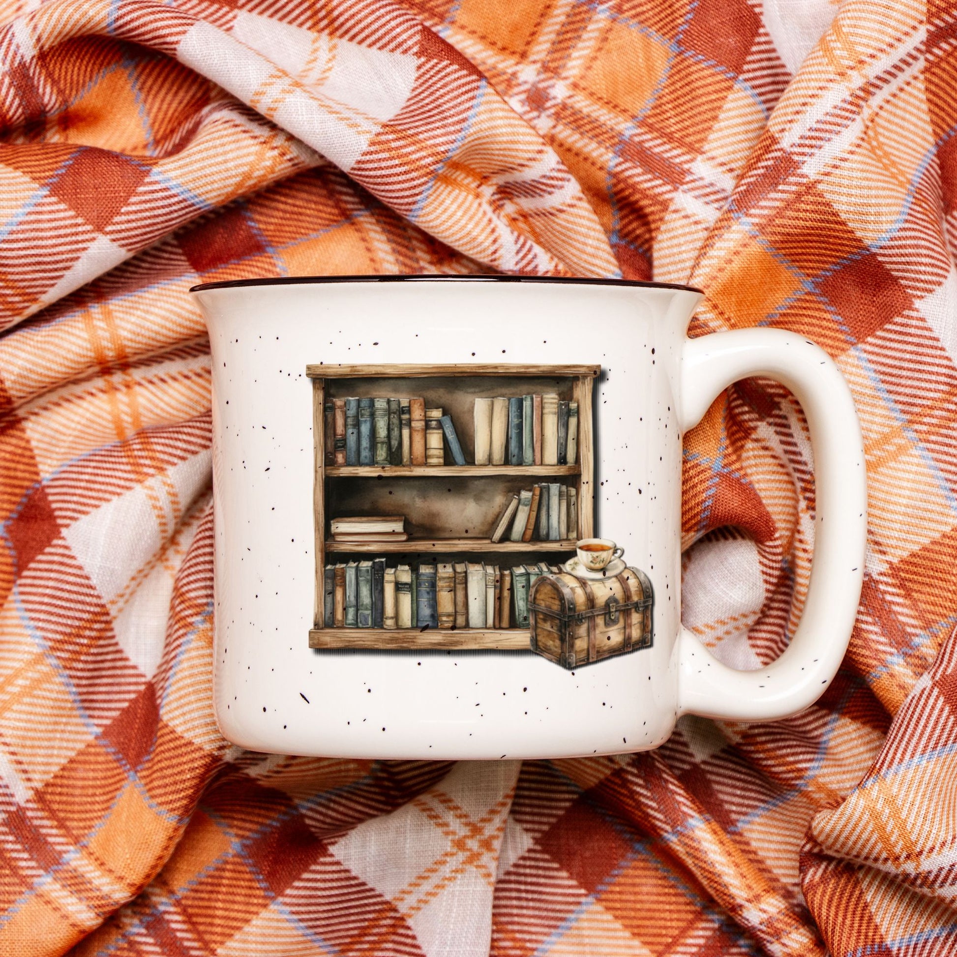 White mug with bookshelf design on a plaid fabric background